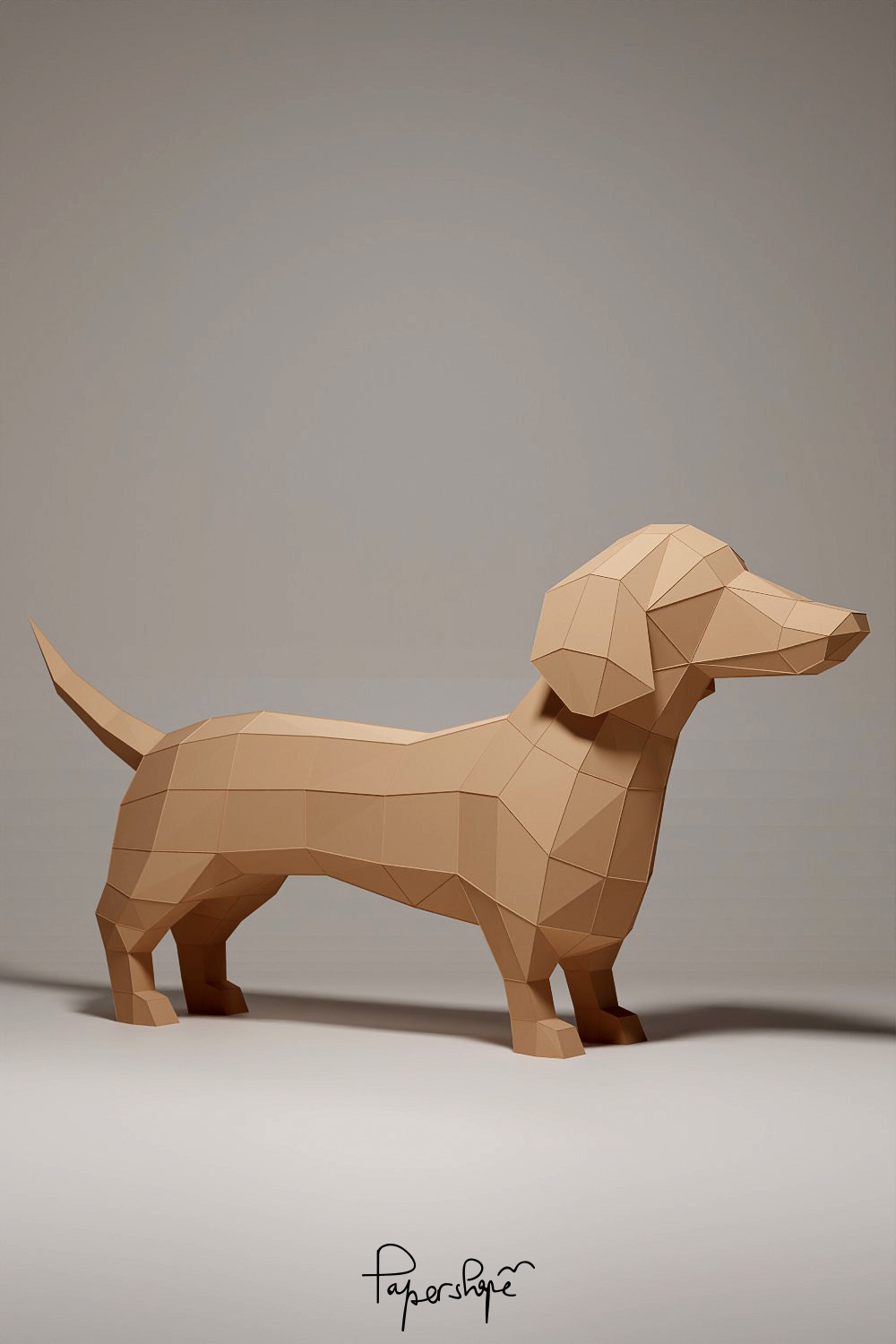 3D Papercraft dachshund "Franz" made of brown paper, photographed from the back left, standing on a light-coloured background.